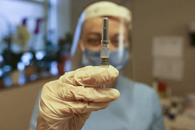 Nurse Arzu Yildirim poses for the photographer as she holds a CoronaVac vaccine, made by Sinovac, currently on phase III clinical trials at Acibadem Hospital in Istanbul, Monday, December 21, 2020. Turkey has ordered 50 million doses of the vaccine and Health Minister Fahrettin Koca said last week that the first batch was expected to arrive within days and vaccination could start at the end of December or early January.Some 12,500 volunteers are taking part in Phase 3 trials of the vaccine across Turkey but the full vaccination programme is expected to start before the trial is completed. (Photo by Emrah Gurel/AP Photo)