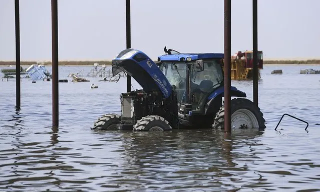 Farm machinery is seen at Hansen Ranches, an area flooded along 6th Avenue, Tuesday afternoon, April 25, 2023 just south of Corcoran, Calif. (Photo by Eric Paul Zamora/The Fresno Bee via AP Photo)