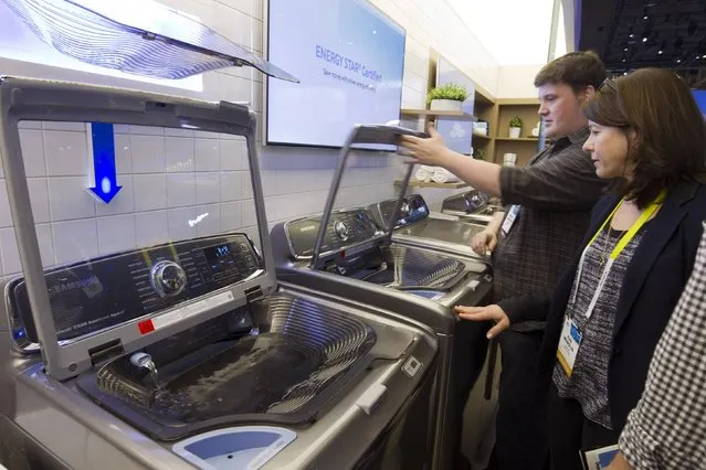A couple looks over an “activewash” Samsung washing machine with a built-in sink during the 2015 International Consumer Electronics Show (CES) in Las Vegas, Nevada January 6, 2015. The sink is used for pre-treating stains and is hinged to lift out of the way when the user loads laundry. (Photo by Steve Marcus/Reuters)