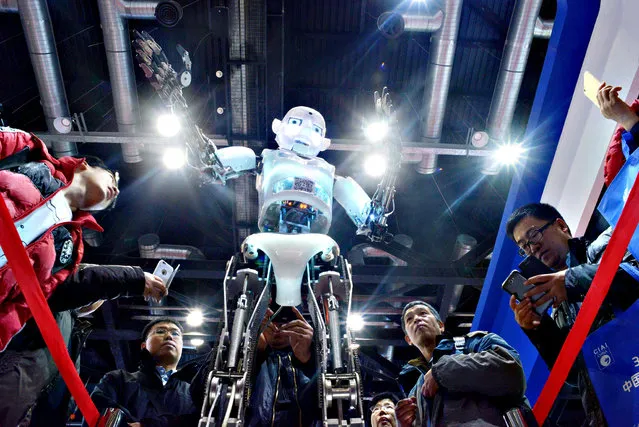 Visitors watch a robot demonstration during the World Robot Conference in Beijing on November 24, 2015. The World Robot Conference being is held in Beijing from November 23 to 25. (Photo by Wang Zhao/AFP Photo)