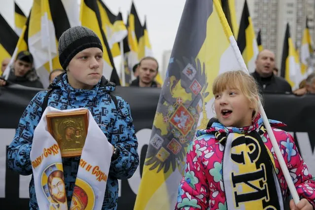 Children hold an icon and a historic flag of the Russian empire as they attend a "Russian March" demonstration on National Unity Day in Moscow, Russia November 4, 2015. Russia marks National Unity Day on November 4 to celebrate the defeat of Polish invaders in 1612. (Photo by Maxim Shemetov/Reuters)