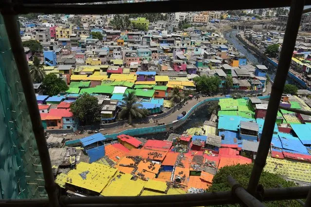 This aerial picture taken on June 2, 2018 shows a view of houses painted in bright colours at a fishing area in Mumbai, India. Mumbai's slums are getting a colourful makeover thanks to an organisation that aims to change how people perceive deprived areas in India's financial capital. (Photo by Punit Paranjpe/AFP Photo)