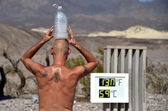 Steve Krofchik of Las Vegas keeps cool with a bottle of ice on his head as the thermometer reads 130 degrees Fahrenheit (54.4 Celsius) at the Furnace Creek Visitors Center in Death Valley, California, U.S. August 17, 2020. (Photo by David Becker/Reuters)