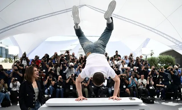 French-Israeli actor Tom Mercier (R) performs acrobatics while posing with French actress Billie Blain during a photocall for the film “Le Regne Animal” at the 76th edition of the Cannes Film Festival in Cannes, southern France, on May 18, 2023. (Photo by Loic Venance/AFP Photo)