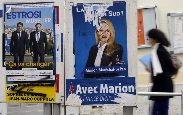 A woman walks past campaign posters of Marion Marechal-Le Pen (R), French National Front political party member and candidate for National Front in the Provence-Alpes-Cote d'Azur (PACA) region and Christian Estrosi (L), mayor of Nice and Les Republicains party candidate, on electoral panels before the second round of the regional elections in Marseille, France, December 8, 2015. (Photo by Jean-Paul Pelissier/Reuters)