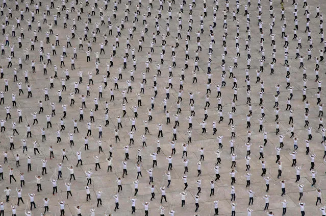 A general view shows performers in formation in a public square beneath the Arch of Triumph in Pyongyang on June 10, 2018. The gathering was understood to be a rehearsal for an expected upcoming Arirang Mass Games event in September. (Photo by Ed Jones/AFP Photo)