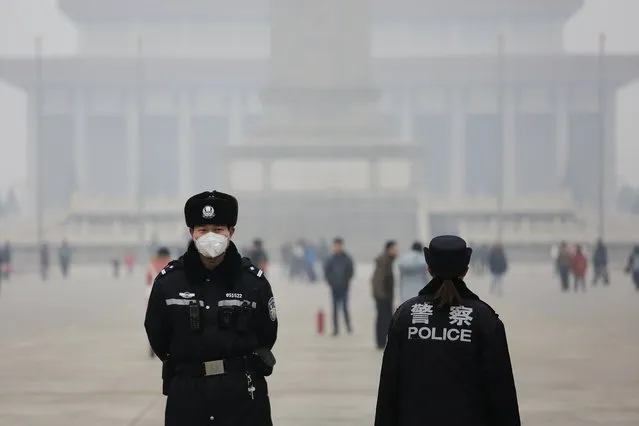 Policemen wear masks protecting from extreme smog at the Tiananmen Square in Beijing December 8, 2015 as China's capital issues its first ever "red alert" for pollution. (Photo by Damir Sagolj/Reuters)
