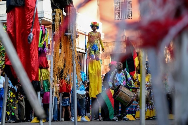 A stilt walker looks on as he performs during a parade at the green zone of the COP16 summit in Cali, Colombia, on October 25, 2024. (Photo by Joaquín Sarmiento/AFP Photo)