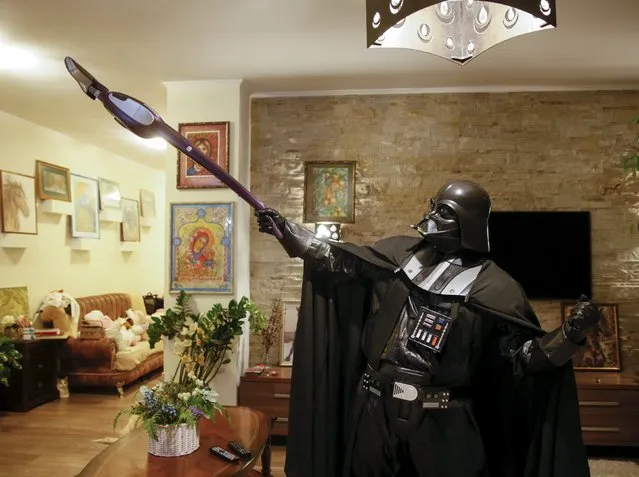 Darth Mykolaiovych Vader, who is dressed as the 'Star Wars' character Darth Vader, poses for a picture with a vacuum cleaner as he cleans his apartment in Odessa, Ukraine, December 2, 2015. (Photo by Valentyn Ogirenko/Reuters)