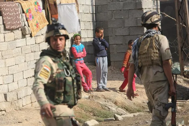 Children look at Iraqi soldiers on a patrol in Intisar district of Mosul, Iraq, November 14, 2016. (Photo by Air Jalal/Reuters)