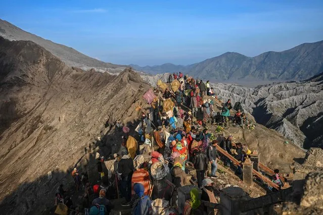 Members of the Tengger sub-ethnic group ascend the active Mount Bromo volcano to present offerings of rice, fruit, livestock and other items as part of the Yadnya Kasada festival in Probolinggo, East Java province on June 5, 2023. (Photo by Juni Kriswanto/AFP Photo)