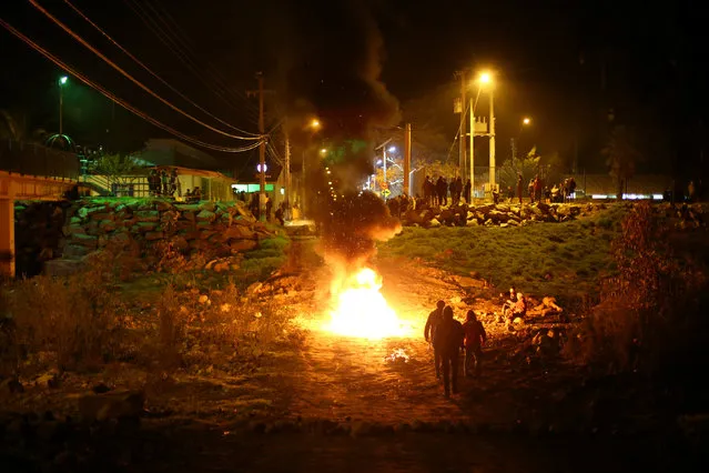 Locals make barricades as they gather to protest against a new industrial waste processing facility that is being constructed in Til Til, Chile, August 15, 2017. (Photo by Ivan Alvarado/Reuters)