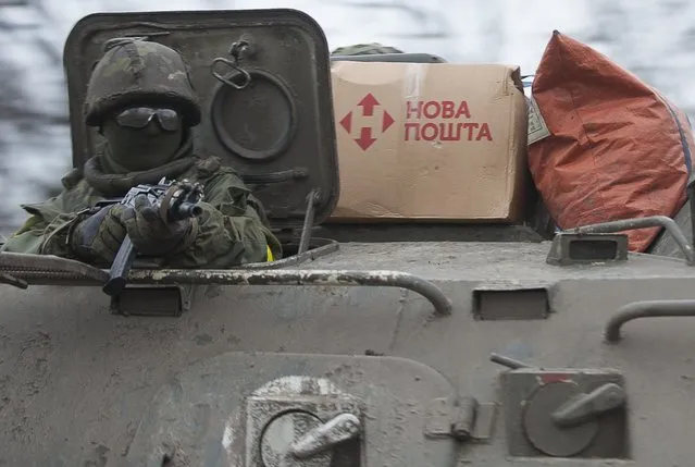 A Ukrainian serviceman holds his position in an APC near Artemivsk, eastern Ukraine, Thursday, February 5, 2015. Fighting between Russia-backed separatists and Ukrainian forces in eastern Ukraine surged in January, raising the death toll to over 5,300 people killed since April. In a new push for peace, the leaders of France and Germany headed Thursday to Kiev and Moscow with a proposal to end the fighting in eastern Ukraine. (Photo by Evgeniy Maloletka/AP Photo)