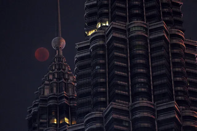 A full moon sets over Petronas Twin Tower during a complete lunar eclipse in Kuala Lumpur, Malaysia, Saturday, July 28, 2018.Skywatchers around much of the world are looking forward to a complete lunar eclipse that will be the longest this century. (Photo by Yam G-Jun/AP Photo)