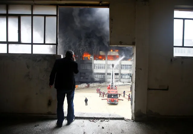 A man watches as firemen try to extinguish a fire at a plastic factory in Istanbul, Turkey, November 22, 2016. The cause of the fire is currently unknown, according to local media. (Photo by Osman Orsal/Reuters)
