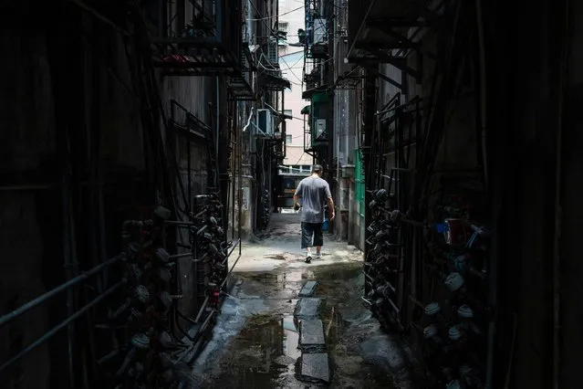 A pedestrian walks along an alley at the Iao Hon neighbourhood in Macau on July 26, 2023. (Photo by Eduardo Leal/AFP Photo)