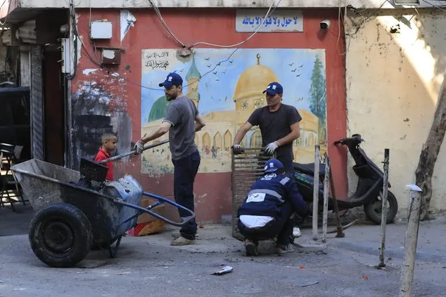 Workers for the agency for Palestinian refugees, or UNRWA, clean a sewer at Ein el-Hilweh Palestinian refugee camp, in the southern port city of Sidon, Lebanon, Tuesday, June 20, 2023. (Photo by Mohammed Zaatari/AP Photo)