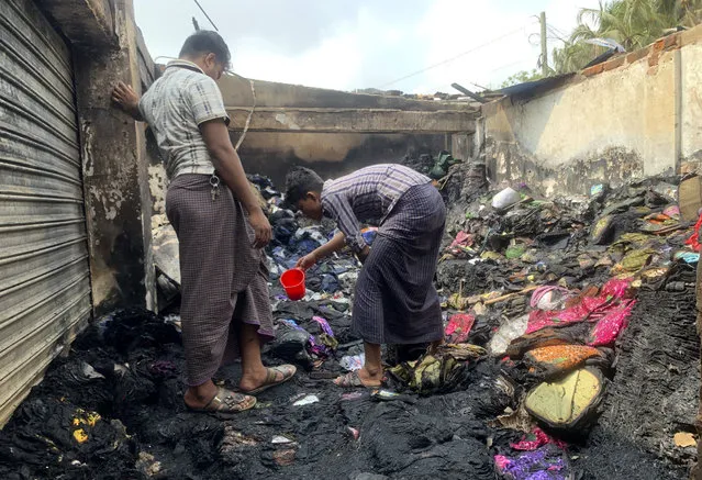 People inspect the debris after a fire in a makeshift market near a Rohingya refugee camp in Kutupalong, Bangladesh, Friday, April 2, 2021. The fire broke out early Friday when residents of the sprawling Kutupalong camp for Myanmar's Rohingya refugees were asleep. (Photo by Shafiqur Rahman/AP Photo)