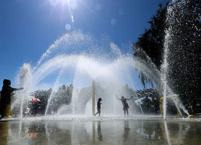 Kids cool off amid the heat on a summer day at the Lemon Park Spray Pool in Fullerton Friday, August 4, 2023. (Photo by Allen J. Schaben/Los Angeles Times via Getty Images)