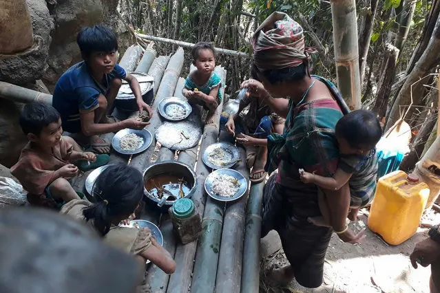 This undated handout from the KNU Doo Pla Ya District released to AFP on April 8, 2021 shows Karen villagers eating in the KNU Brigade 5 region in Myanmar's Karen state, after air strikes in the area following the February military coup. (Photo by Handout/KNU DOO PLA YA DISTRICT/AFP Photo)