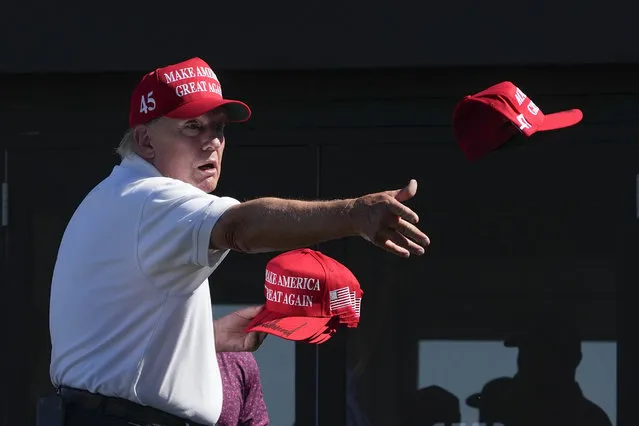 Former President Donald Trump throws autographed caps to the crowd during the final round of the Bedminster Invitational LIV Golf tournament in Bedminster, N.J., Sunday, August 13, 2023. (Photo by Seth Wenig/AP Photo)