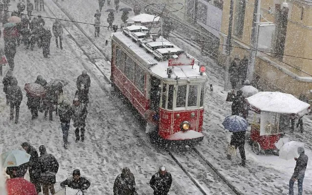 People brave the cold and snow as they walk in the main pedestrian street of Istiklal in central Istanbul February 17, 2015. (Photo by Murad Sezer/Reuters)