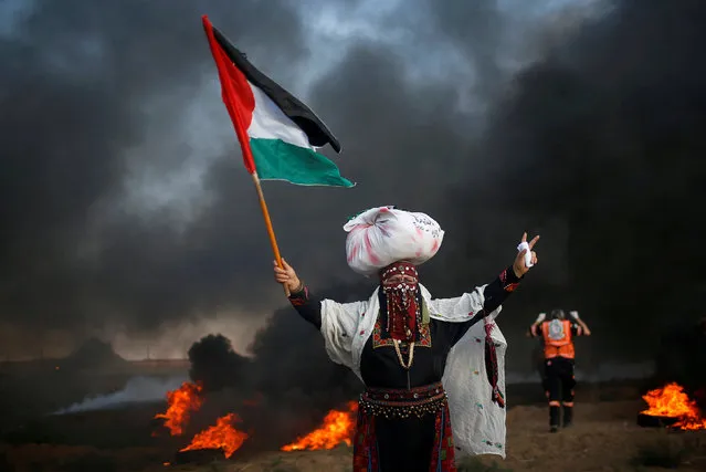 A woman holds a Palestinian flag during a protest calling for lifting the Israeli blockade on Gaza and demand the right to return to their homeland, at the Israel-Gaza border fence, east of Gaza City September 14, 2018. (Photo by Mohammed Salem/Reuters)