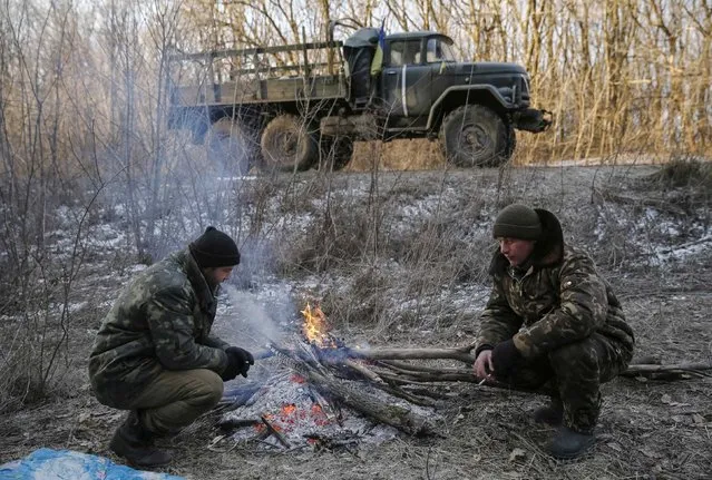 Ukrainian servicemen rest by a fire after their truck broke down near Artemivsk February 19, 2015. (Photo by Gleb Garanich/Reuters)