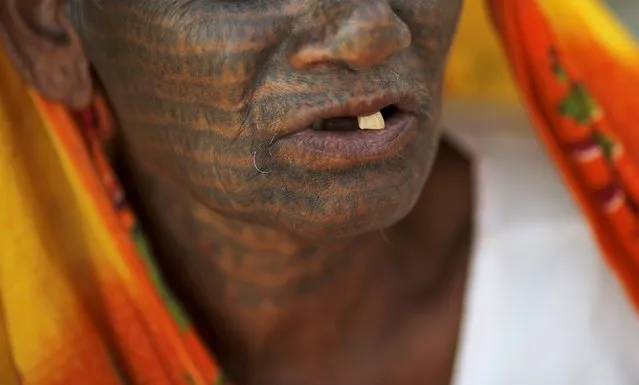 Sumitra Devi, 70, a follower of Ramnami Samaj, who has tattooed the name of the Hindu god Ram on her entire face, poses for a picture outside her house in the village of Chapora, in the eastern state of Chhattisgarh, India, November 15, 2015. (Photo by Adnan Abidi/Reuters)