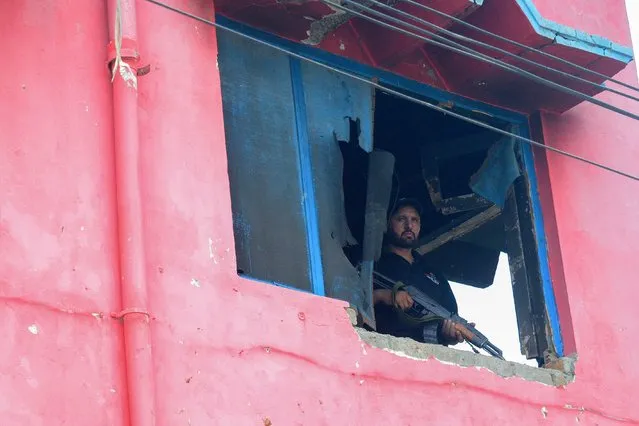 A policeman stands guard on the torched Salvation Army Church in Jaranwala on the outskirts of Faisalabad on August 20, 2023, after mob attacked several Pakistani churches over blasphemy allegations. A Muslim cleric is among a dozen people being investigated for using mosque loudspeakers to order protests against alleged blasphemy by Christians which erupted into mob violence in Pakistan earlier this week, a senior police official said. More than 80 Christian homes and 19 churches were vandalised when hundreds rampaged through a Christian neighbourhood in Jaranwala in Punjab province on August 16. (Photo by Ghazanfar Majid/AFP Photo)