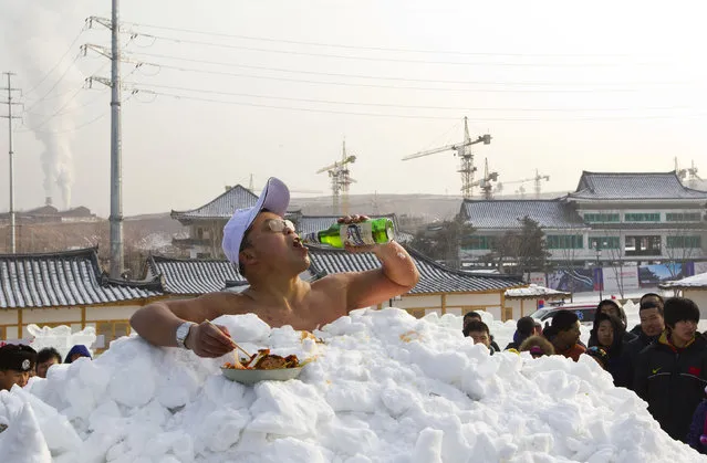 Jin Songhao drinks beer as he sits in snow during a cold endurance performance in Yanji, Jilin province, January 12, 2013. Jin set the Guinness record for the longest time spent in direct full body contact with snow on January 17, 2011 with a time of 46 minutes and seven seconds, local media reported. (Photo by Reuters/Stringer)