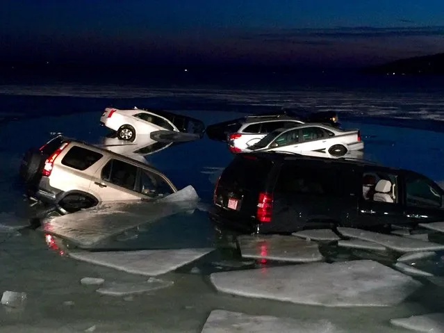 Multiple vehicles are submerged after falling into the ice on Geneva Lake in Lake Geneva, Wis., on Satrurday, February 6, 2016. The cars were parked on the ice of the lake when they began breaking through Saturday. Officers arrived and found 15 vehicles were partially submerged in the water. No one was hurt. (Photo by Daniel Gaitan/The Kenosha News via AP Photo)