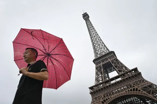 A man walks past a tower modelled on the Eiffel Tower near a residential area in Hangzhou, host city of the 2022 Asian Games, in China's eastern Zhejiang province on September 22, 2023. (Photo by Wang Zhao/AFP Photo)