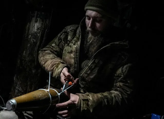 Ukrainian serviceman prepares an explosive device for a kamikaze FPV drone near a front line, amid Russia's attack on Ukraine, near the city of Bakhmut in Donetsk region, Ukraine on December 12, 2023. (Photo by Inna Varenytsia/Reuters)