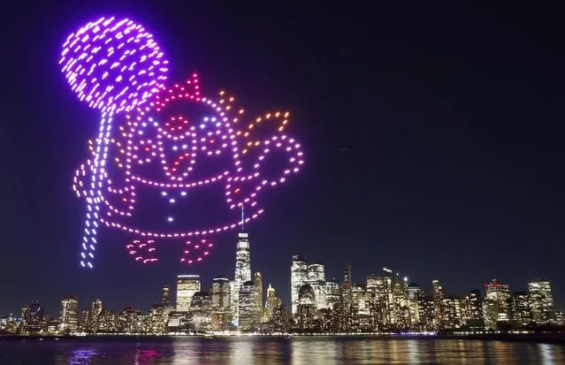 A character holding a lollipop is created by 500 drones over the skyline of lower Manhattan and One World Trade Center during an advertising promotion for the 10th anniversary of the video game Candy Crush Saga in New York City on November 3, 2022, as seen from Jersey City, New Jersey. (Photo by Gary Hershorn/Getty Images)