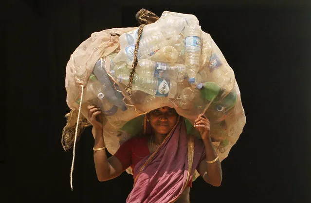 An Indian woman carries a sack of used plastic bottles to be sold at a recycled plant on the International Woman's Day in the eastern Indian city of Bhubaneswar, India, Tuesday, March 8, 2016. (Photo by Biswaranjan Rout/AP Photo)