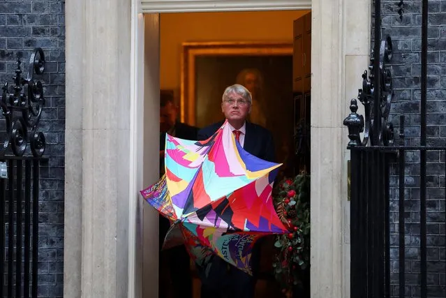 Britain's Minister of State for Development and Africa Andrew Mitchell uses an umbrella outside 10 Downing Street in London on December 19, 2023. (Photo by Toby Melville/Reuters)