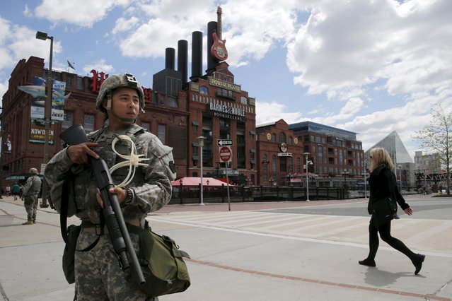 National Guard troops patrol in front of the Power Plant in the Inner Harbor of Baltimore, Maryland, United States April 28, 2015. U.S. President Obama on Tuesday said rioting in Baltimore emphasized the need for national “soul searching” on the way police forces deal with the public. Obama, in his first public statement about Freddie Gray, a Maryland black man who died of a broken spine after being arrested, said such cases are not new. (Photo by Jim Bourg/Reuters)