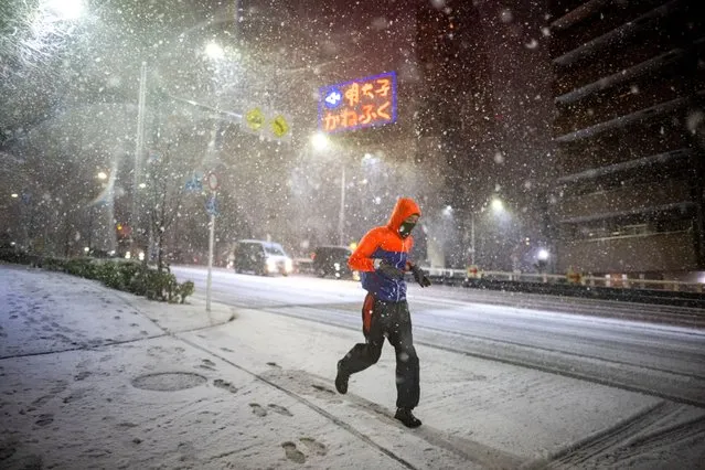 )A man runs amid snowfall in Koto, Tokyo on February 5, 2024. (Photo by Philip Fong/AFP Photo)