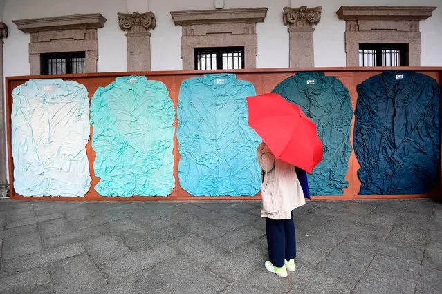 A visitor views an installation called “Tele in Camicia”, five shades of blue by Ludovica Diligu with Labo.Art exhibited at the Milan University (L'Università degli Studi di Milano) during the Fuorisalone 2019 design week on April 11, 2019. The Milan Furniture fair week is taking place in various locations across Milan from April 9 through 14, 2019. (Photo by Miguel Medina/AFP Photo)