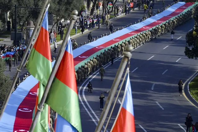 Soldiers carry a 440-meter-long (1,444-foot) Azerbaijan national flag to celebrate the Victory Day in Baku, Azerbaijan, Monday, November 8, 2021. The celebrations mark the one-year anniversary of Azerbaijan's victory in six weeks of heavy fighting over Nagorno-Karabakh. (Photo by AP Photo/Stringer)