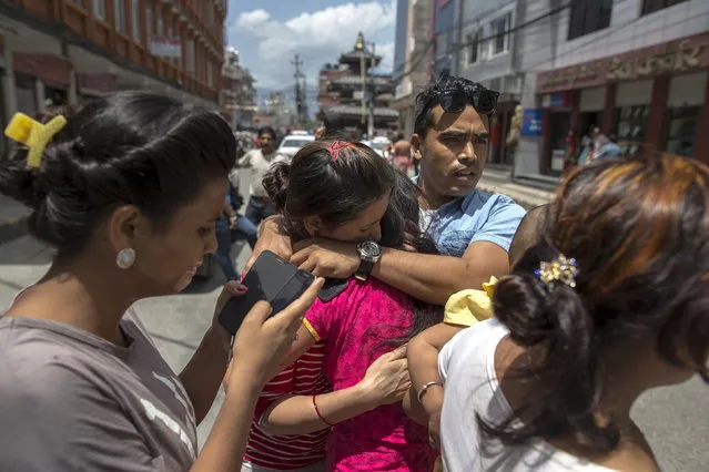 Local residents comfort each others during an earthquake in central Kathmandu, Nepal, May 12, 2015. (Photo by Athit Perawongmetha/Reuters)