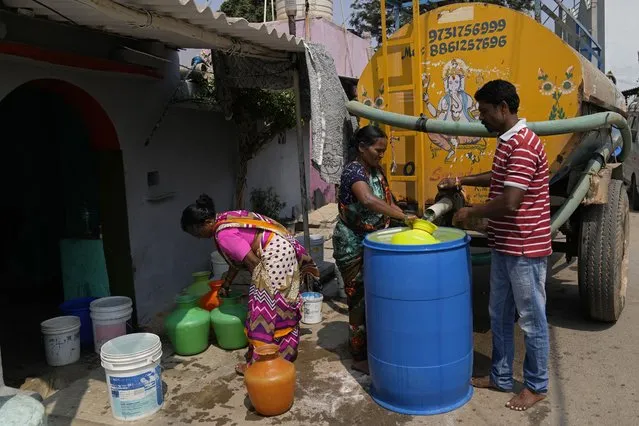 Residents of Ambedkar Nagar, a low-income settlement in the shadows of global software companies in Whitefield neighborhood, collect potable water from a private tanker in Bengaluru, India, Monday, March 11, 2024. Water levels are running desperately low, particularly in poorer regions, resulting in sky-high costs for water and a quickly dwindling supply. (Photo by Aijaz Rahi/AP Photo)