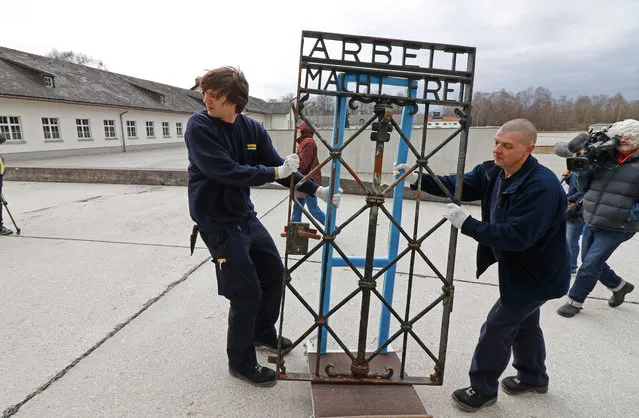 Two freight forwarders transport the historic gate of the memorial site of the former concentration camp Dachau back to its original site in Dachau, Germany, 22 February 2017. The 100 kilogram gate made of wrought iron was stolen in 2014 and reappeared in November 2016 near the city of Bergen in Norway. The theft has yet to be clarified. (Photo by Uwe Lein/AFP Photo)