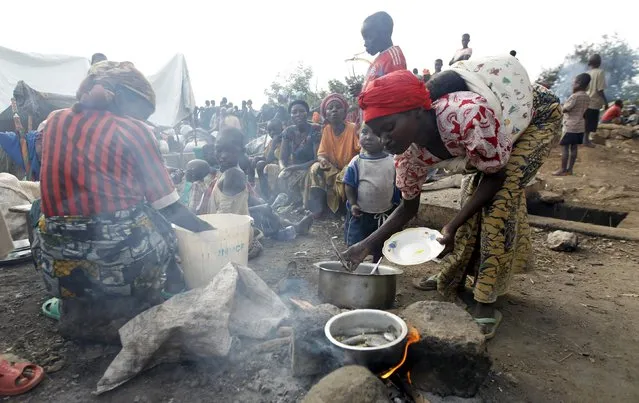 A Burundian refugee cooks a meal on the shores of Lake Tanganyika in Kagunga village in Kigoma region in western Tanzania, as they wait for MV Liemba to transport them to Kigoma township, May 18, 2015. (Photo by Thomas Mukoya/Reuters)