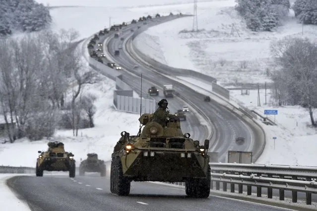 A convoy of Russian armored vehicles moves along a highway in Crimea, Tuesday, January 18, 2022. Russia has concentrated an estimated 100,000 troops with tanks and other heavy weapons near Ukraine in what the West fears could be a prelude to an invasion. The Biden administration is unlikely to answer a further Russian invasion of Ukraine by sending U.S. combat troops. But it could pursue a range of less dramatic yet still risky options, including giving military support to a post-invasion Ukrainian resistance. (Photo by AP Photo/Stringer)