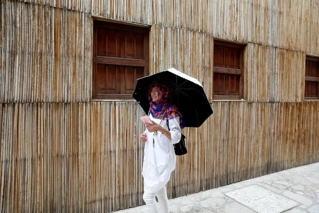 A tourist holds an umbrella as she walks past an old house at Al Bastakiya, a historic district in Dubai, UAE March 7, 2016. (Photo by Ahmed Jadallah/Reuters)