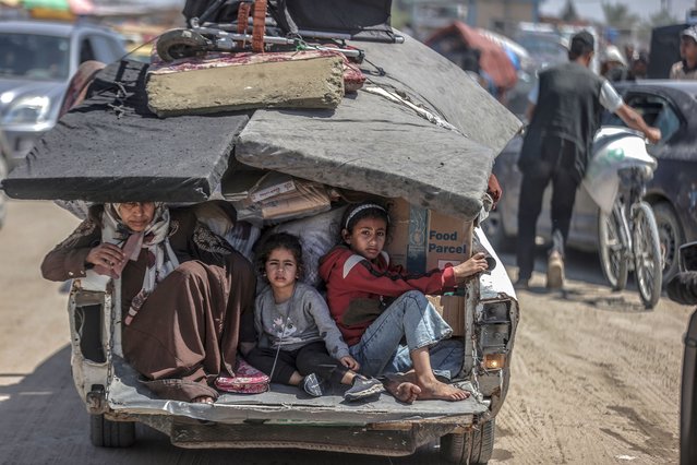 Children sit back on a truck as Palestinians with their packed belongings, continue to depart from the eastern neighborhoods of the city due to ongoing Israeli attacks in Rafah, Gaza on May 8, 2024. (Photo by Ali Jadallah/Anadolu via Getty Images)
