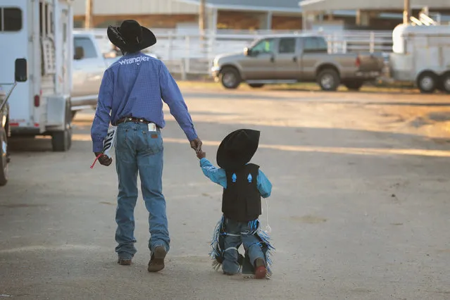 Bernard Daniels walks with his grandson Zion Williams  before the start of competition at the Bill Pickett Invitational Rodeo on April 1, 2017 in Memphis, Tennessee. (Photo by Scott Olson/Getty Images)