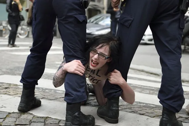 A bare-chested activist shouts slogans as she is evacuated by police outside the Egyptian embassy in Paris on April 30, 2014 during a demonstration against death sentences handed by an Egyptian court to 683 alleged Islamists. (Photo by Eric Feferberg/AFP Photo)